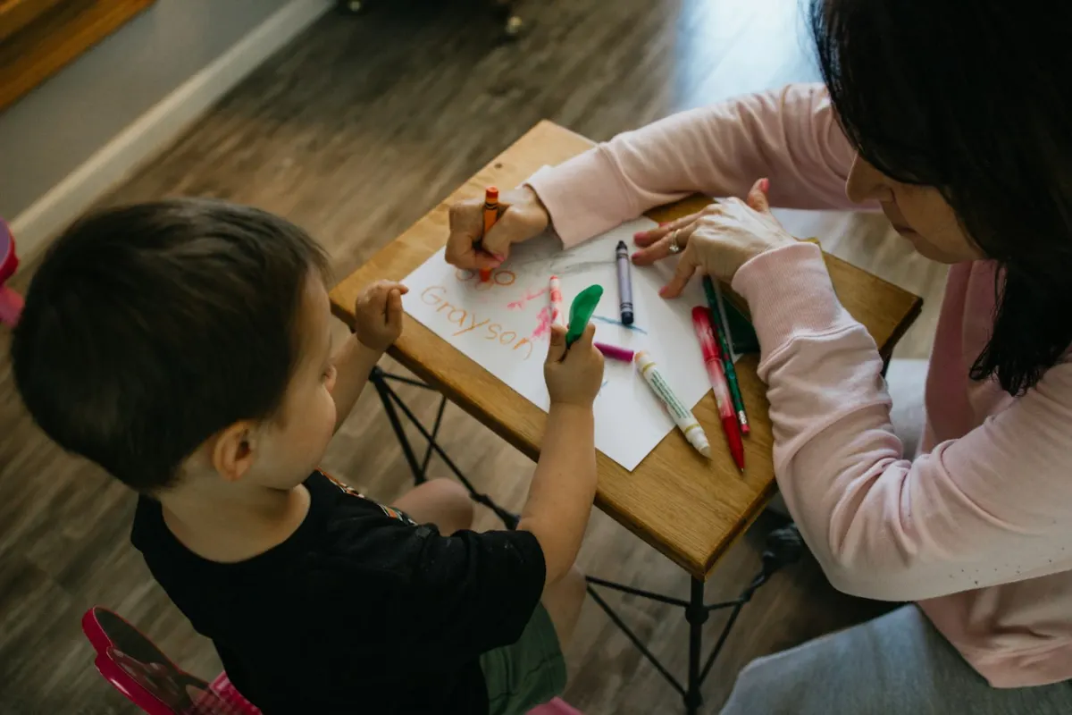 Un adulte et un enfant colorient ensemble