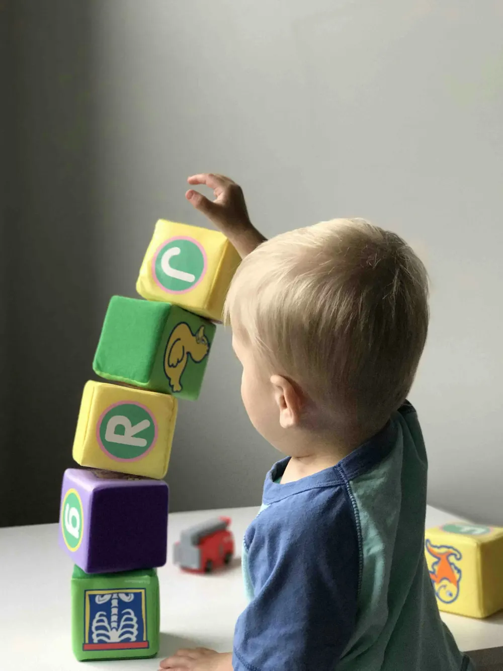 Un enfant empile des cubes de couleur