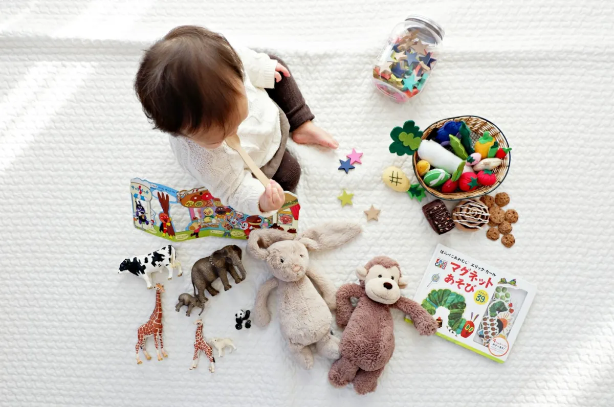 Un bébé découvre des jouets d'éveil sur un tapis blanc